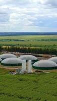 Biogas Bauernhof auf Grün Felder. modern Landwirtschaft Pflanze im Natur. verlängerbar Energie von Biomasse. Antenne Sicht. Vertikale video