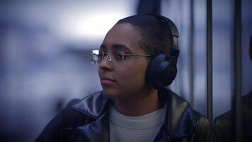 urban livsstil porträtt av avslappnad kvinna person med hörlurar spelar ljud video