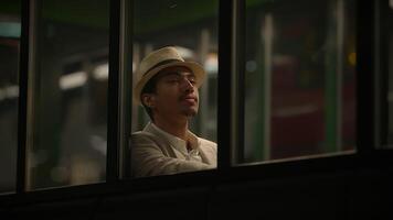 jovem homem esperando sozinho às trem estação plataforma às noite video