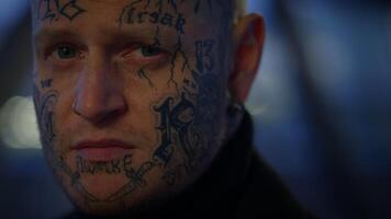 poco convencional joven hombre cubierto en tatuajes y oscuro negro ropa video