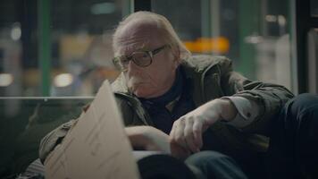 äldre hemlös man lidande från fattigdom ser för hjälp på tåg station video