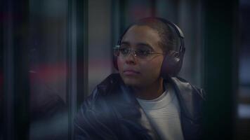 un mujer en lentes y auriculares disfrutando un evento en un oscuro habitación video