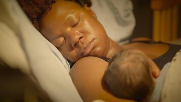 svart kvinna med lockigt hår vilar i leverans rum med spädbarn barn video