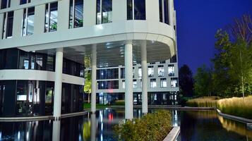 Pattern of office buildings windows illuminated at night. Glass architecture ,corporate building at night - business concept. photo