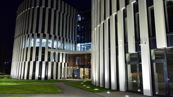 Pattern of office buildings windows illuminated at night. Glass architecture ,corporate building at night - business concept. photo