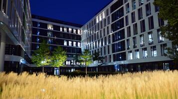 Pattern of office buildings windows illuminated at night. Glass architecture ,corporate building at night - business concept. photo