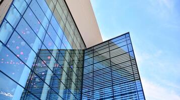 vaso edificio con transparente fachada de el edificio y azul cielo. estructural vaso pared reflejando azul cielo. resumen moderno arquitectura fragmento. contemporáneo arquitectónico antecedentes. foto