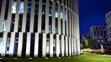 Pattern of office buildings windows illuminated at night. Glass architecture ,corporate building at night - business concept. photo