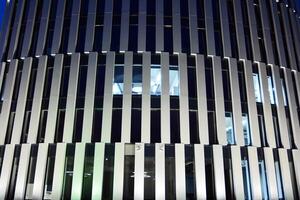 Pattern of office buildings windows illuminated at night. Glass architecture ,corporate building at night - business concept. photo