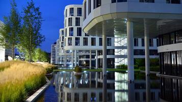 Pattern of office buildings windows illuminated at night. Glass architecture ,corporate building at night - business concept. photo