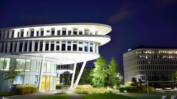 Pattern of office buildings windows illuminated at night. Glass architecture ,corporate building at night - business concept. photo