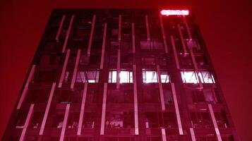 Night architecture - building with glass facade. Modern building in business district. Concept of economics, financial. Photo of commercial office building exterior. Abstract image of office building