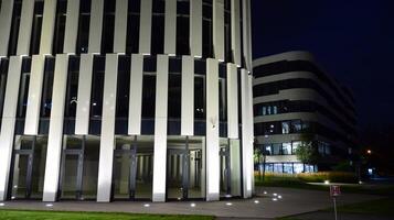 Pattern of office buildings windows illuminated at night. Glass architecture ,corporate building at night - business concept. photo