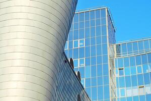 Structural glass wall reflecting blue sky. Abstract modern architecture fragment photo