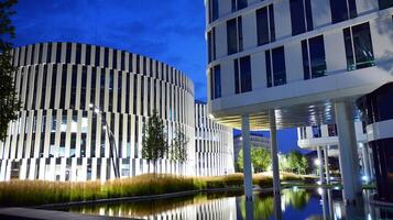 Pattern of office buildings windows illuminated at night. Glass architecture ,corporate building at night - business concept. photo