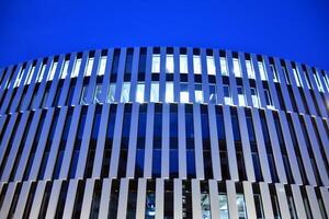 Pattern of office buildings windows illuminated at night. Glass architecture ,corporate building at night - business concept. photo