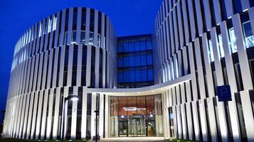 Pattern of office buildings windows illuminated at night. Glass architecture ,corporate building at night - business concept. photo