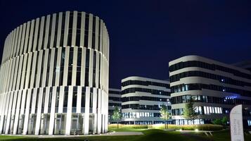 Pattern of office buildings windows illuminated at night. Glass architecture ,corporate building at night - business concept. photo