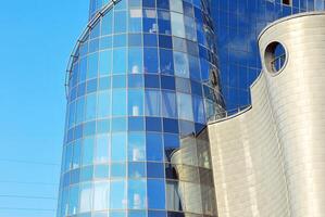 Structural glass wall reflecting blue sky. Abstract modern architecture fragment photo