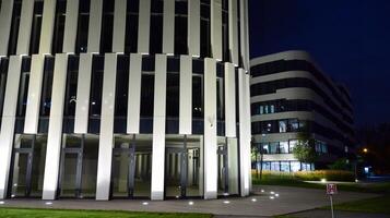 Pattern of office buildings windows illuminated at night. Glass architecture ,corporate building at night - business concept. photo