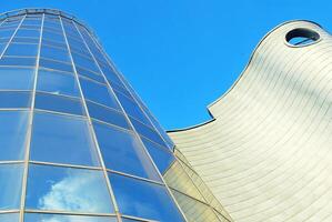Structural glass wall reflecting blue sky. Abstract modern architecture fragment photo