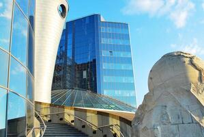 Structural glass wall reflecting blue sky. Abstract modern architecture fragment photo