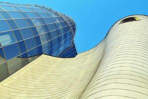 Structural glass wall reflecting blue sky. Abstract modern architecture fragment photo