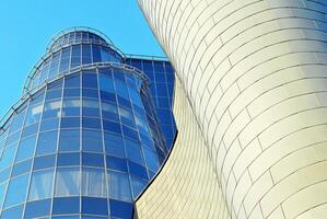 Structural glass wall reflecting blue sky. Abstract modern architecture fragment photo