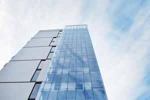 vaso edificio con transparente fachada de el edificio y azul cielo. estructural vaso pared reflejando azul cielo. resumen moderno arquitectura fragmento. contemporáneo arquitectónico antecedentes. foto