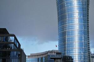 Structural glass wall reflecting blue sky. Abstract modern architecture fragment photo