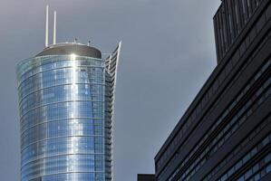 Structural glass wall reflecting blue sky. Abstract modern architecture fragment photo