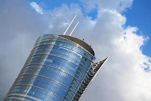 Structural glass wall reflecting blue sky. Abstract modern architecture fragment photo