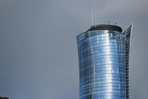 Structural glass wall reflecting blue sky. Abstract modern architecture fragment photo