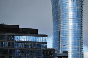 Structural glass wall reflecting blue sky. Abstract modern architecture fragment. photo