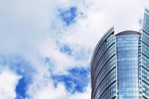 Structural glass wall reflecting blue sky. Abstract modern architecture fragment photo