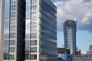 Structural glass wall reflecting blue sky. Abstract modern architecture fragment photo