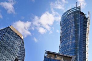 Structural glass wall reflecting blue sky. Abstract modern architecture fragment. photo