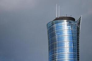 Structural glass wall reflecting blue sky. Abstract modern architecture fragment photo