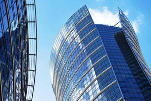 Structural glass wall reflecting blue sky. Abstract modern architecture fragment. photo