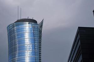 Structural glass wall reflecting blue sky. Abstract modern architecture fragment. photo