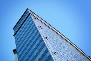 vaso edificio con transparente fachada de el edificio y azul cielo. estructural vaso pared reflejando azul cielo. resumen moderno arquitectura fragmento. contemporáneo arquitectónico antecedentes. foto