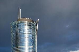 Structural glass wall reflecting blue sky. Abstract modern architecture fragment. photo