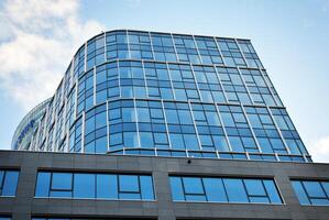 Structural glass wall reflecting blue sky. Abstract modern architecture fragment photo