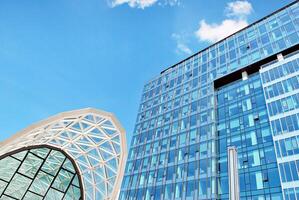 vaso edificio con transparente fachada de el edificio y azul cielo. estructural vaso pared reflejando azul cielo. resumen moderno arquitectura fragmento. contemporáneo arquitectónico antecedentes. foto