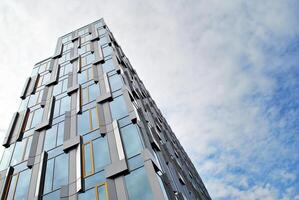 Glass building with transparent facade of the building and blue sky. Structural glass wall reflecting blue sky. Abstract modern architecture fragment. Contemporary architectural background. photo