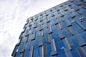 vaso edificio con transparente fachada de el edificio y azul cielo. estructural vaso pared reflejando azul cielo. resumen moderno arquitectura fragmento. contemporáneo arquitectónico antecedentes. foto