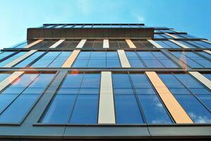 Glass building with transparent facade of the building and blue sky. Structural glass wall reflecting blue sky. Abstract modern architecture fragment. Contemporary architectural background. photo