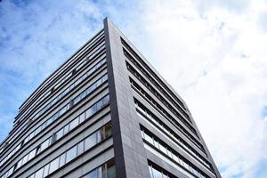 Glass building with transparent facade of the building and blue sky. Structural glass wall reflecting blue sky. Abstract modern architecture fragment. Contemporary architectural background. photo