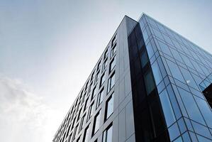 vaso edificio con transparente fachada de el edificio y azul cielo. estructural vaso pared reflejando azul cielo. resumen moderno arquitectura fragmento. contemporáneo arquitectónico antecedentes. foto