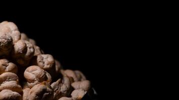 Chickpeas or garbanzos justified at left of screen turning on black background video